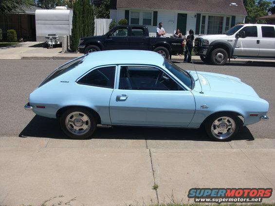 Light blue 1970s hatchback car, side view, with chrome wheels and a "Pinto" badge visible