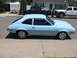1972 Ford Pinto - A light blue 1970s hatchback car is parked on a suburban street next to other vehicles.