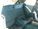 1972 Ford Pinto - The rear interior of a car shows blue vinyl seats and carpeting.