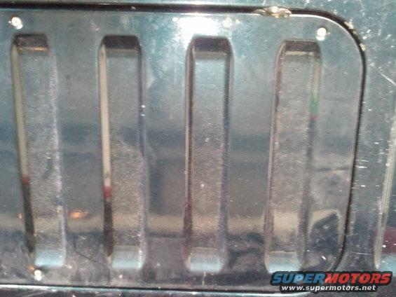 Close-up of a dark-colored grille with vertical slots