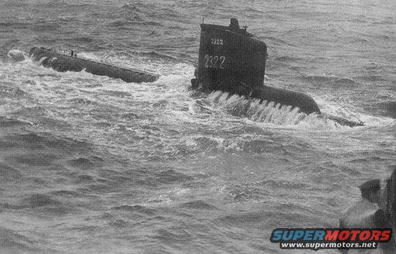Two submarines are in choppy water. One submarine has the number 2322 visible on its sail