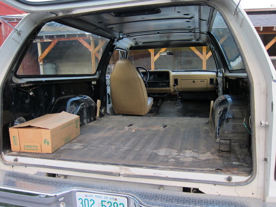 Interior view of a 1987 Dodge 1500 pickup truck, showing the empty bed and cab with one seat