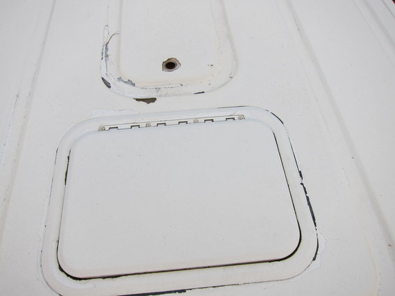 White metal panel with two rectangular access doors, one with visible hinges