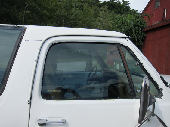 1987 Dodge 1500 side view showing interior and door handle. A sticker is visible on the driver's side window