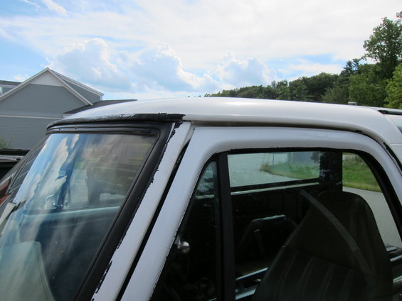 White truck cab roof and window trim. Some peeling paint on the trim