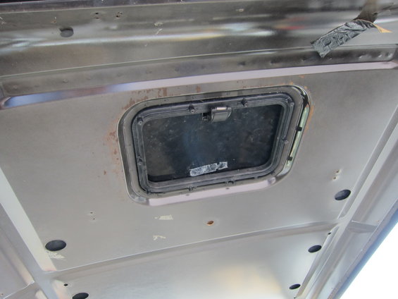 Interior roof panel with a small, rectangular window and latch