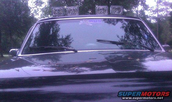 Dark SUV front view with four roof lights and BDS sticker on windshield