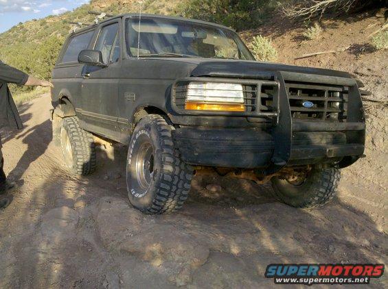 1995 Ford Bronco on a rocky dirt road, front bull bar visible