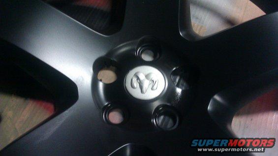 Close-up of a black wheel with a silver Ram logo in the center