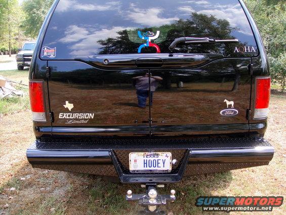 Black Ford Excursion Limited SUV rear view, diamond plate bumper, Texas license plate HOOEY, trailer hitch