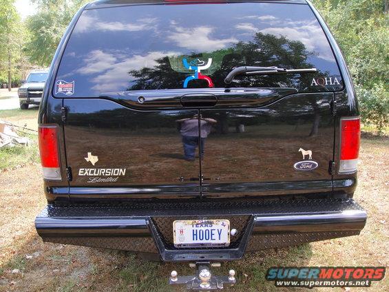 Black SUV rear with 'EXCURSION Limited' badge and Texas license plate 'HOOEY'