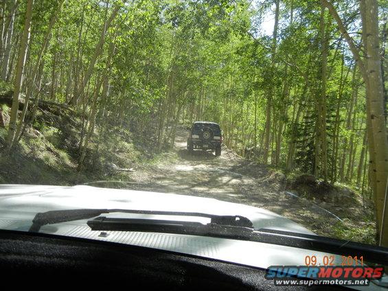 SUV from behind on a dirt road, seen from inside another vehicle