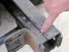 1993 Ford F-250 - A finger points to a crack in the metal frame of a vehicle, indicating damage.