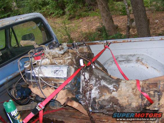 Engine and transmission secured with red straps in the bed of a pickup truck