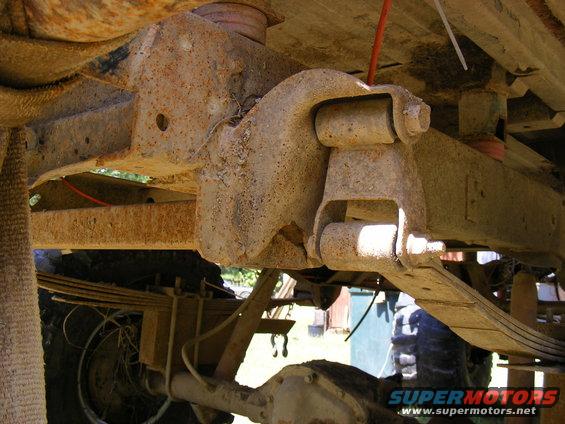 Undercarriage view of rusty leaf springs and suspension parts