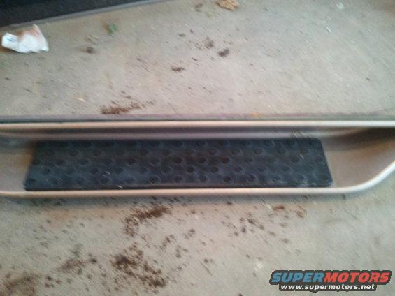 Tan running board with black textured step pad, viewed from above