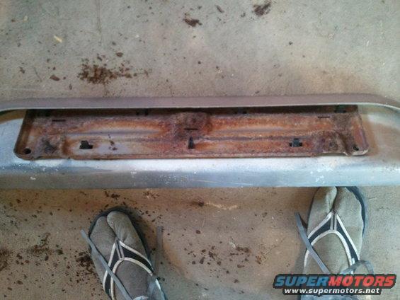 Rusted license plate bracket on a bumper
