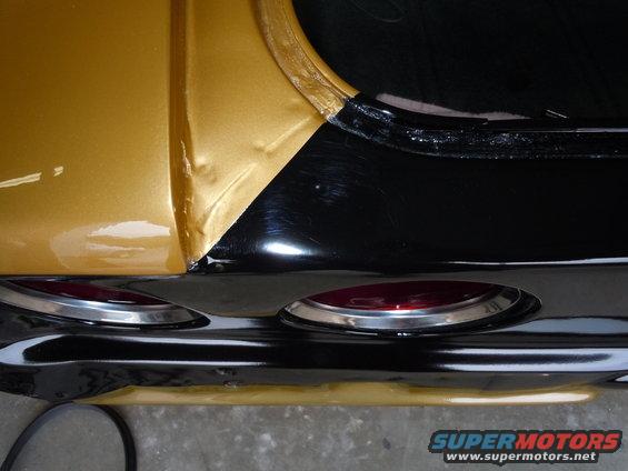 Gold and black 1970 Chevrolet Camaro rear quarter panel with chrome trim and red taillights