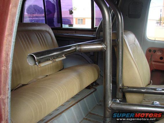 Interior view of a 1979 Ford Bronco with a custom roll cage and tan seats