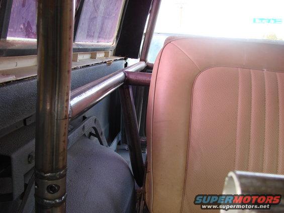 Interior shot of a vehicle's tan seat and metal roll cage tubing