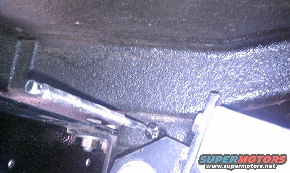 Close-up of parking brake cable assembly with Supermotors.net logo