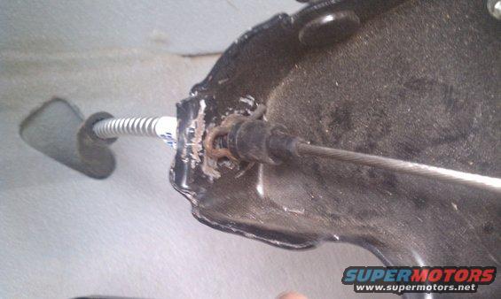 Parking brake cable assembly with metal housing and coiled spring