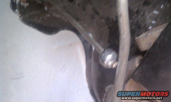 Close-up of a metal parking brake linkage with a spherical joint