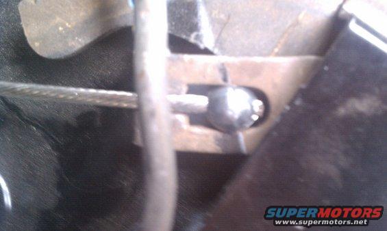 Close-up of a parking brake cable mechanism with a metal ball end