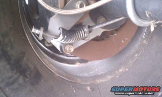 Close-up of a parking brake assembly with a cable and spring