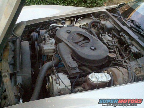 1982 Chevrolet Corvette engine bay with V8 engine, air cleaner, alternator, and brake master cylinder visible