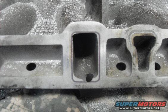 Aluminum intake manifold with machined ports and visible debris