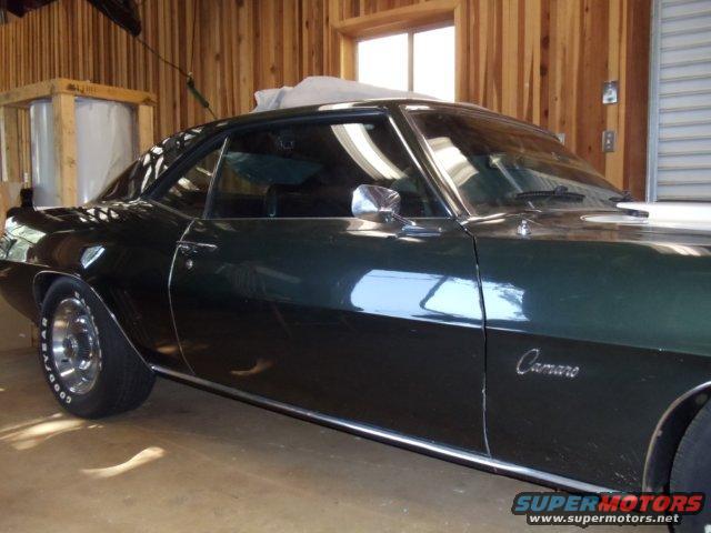 1969 Chevrolet Camaro coupe, dark green paint, side view, in a garage