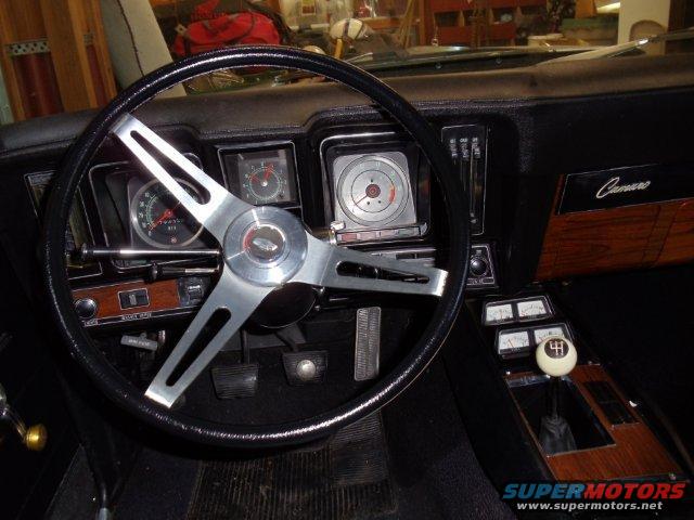 1969 Chevrolet Camaro interior with wood grain trim, a four-spoke steering wheel, and a floor shifter