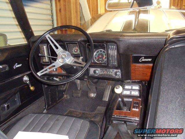 1969 Chevrolet Camaro interior showing dashboard, steering wheel, and center console with wood grain trim