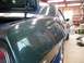 1969 Chevrolet Camaro - The rear of a dark green coupe is visible with the trunk open, reflecting the garage interior.