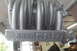 1997 Ford Ranger - A silver intake manifold with 'Ford 5.0' embossed on its side is shown hanging in a workshop.