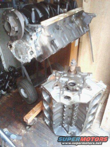 engine block and some engine parts on a cart