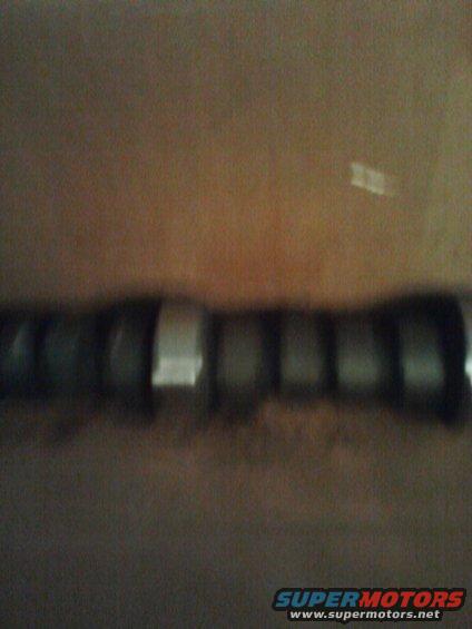 Camshaft with multiple lobes, some with reflective surfaces