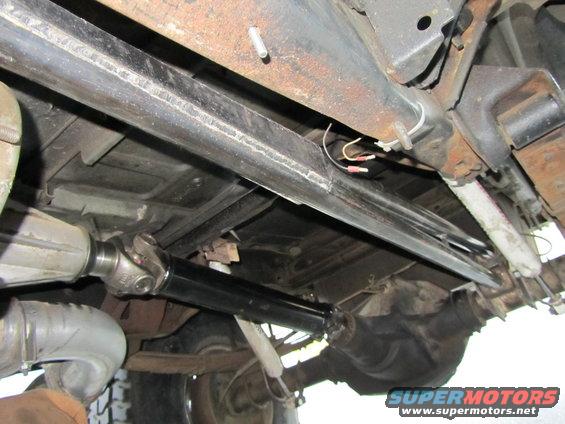 Underside of vehicle showing driveshaft, differential, and frame components