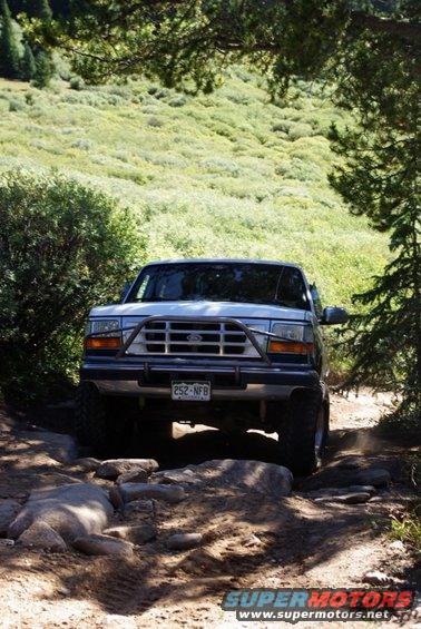 White Ford Bronco with brush guard on rocky trail