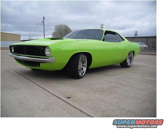 Lime green muscle car with chrome wheels parked on concrete