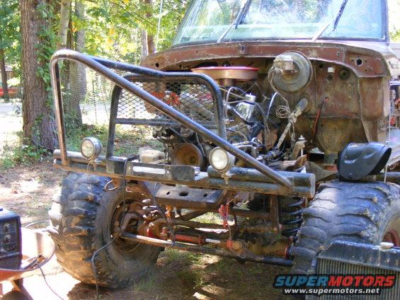 Off-road vehicle front with custom bumper, exposed engine, and large tires