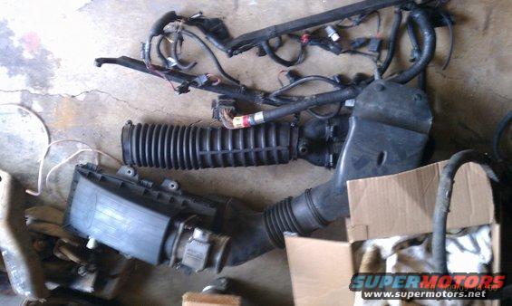 Engine air intake parts and wiring harness on concrete floor