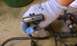 1992 Ford Bronco - A gloved hand holds a gray automotive sensor with visible black connectors and wires attached.