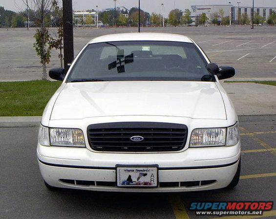 Front view of a white 1999 Ford Crown Victoria parked in an empty lot