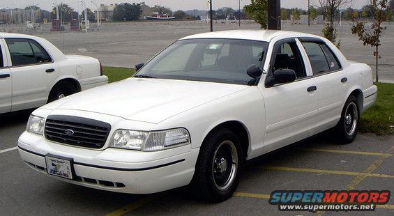 White sedan with black grille and black rims, parked in a lot. Visible license plate