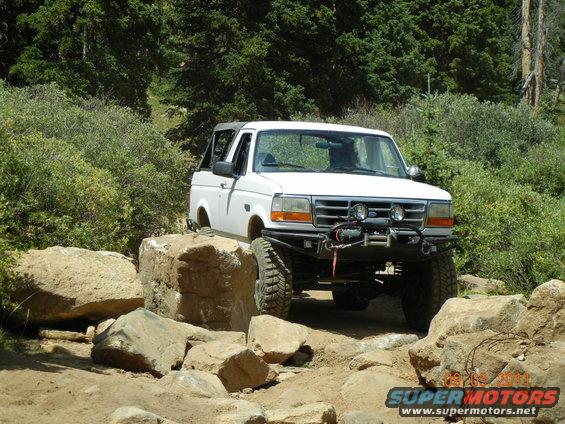 White 1996 Ford Bronco with winch on rocky terrain