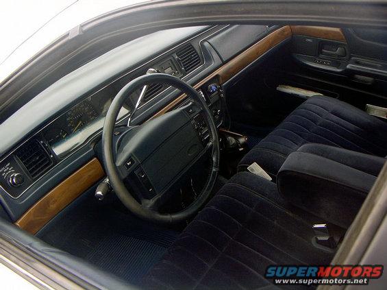 1999 Ford Crown Victoria interior with blue velour seats and wood trim dashboard
