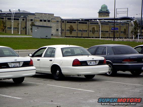 White 1998 Ford Crown Victoria parked next to a dark sedan
