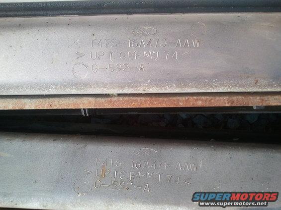 Two identical metal parts stamped with Ford logo, part number F4TS-16A470-AAW, and other codes
